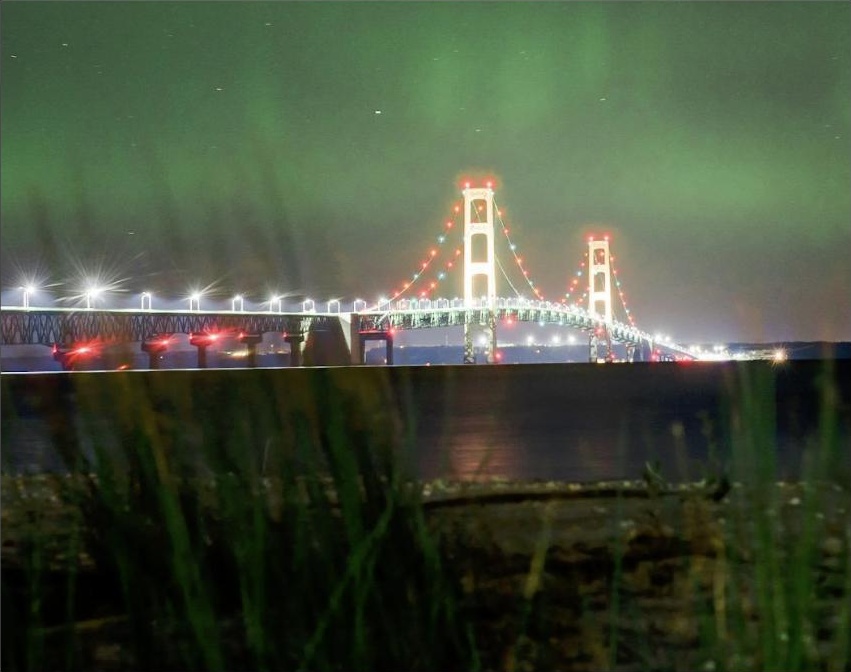 Aurora boreal sobre uma ponte iluminada